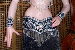 Particolare cintura riccamente decorata con paillettes e frange di perline argentate
